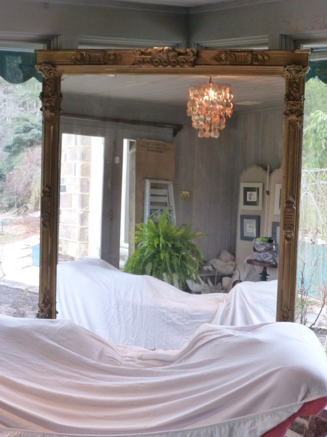 A peek at the mirror in place (and the chandelier, dressing screen, etc. reflected in the mirror).  The settee is covered with a sheet, just to keep the dust off, and the window treatments are not yet installed.  