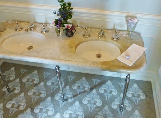 The star of the room is the custom-designed marble and limestone floor inspired by materials original to the house.