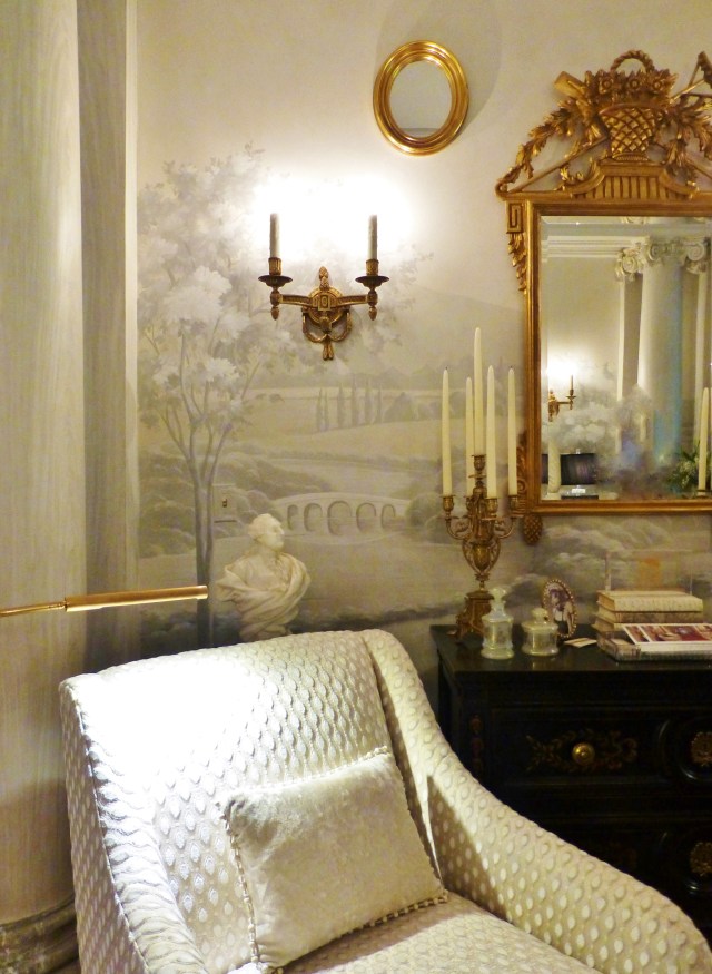 The furnishings and accessories are light with gold metallic accents.  The sconces and mirrors are beautiful, and the textured fabric adds so much warmth to the cool neutral space.