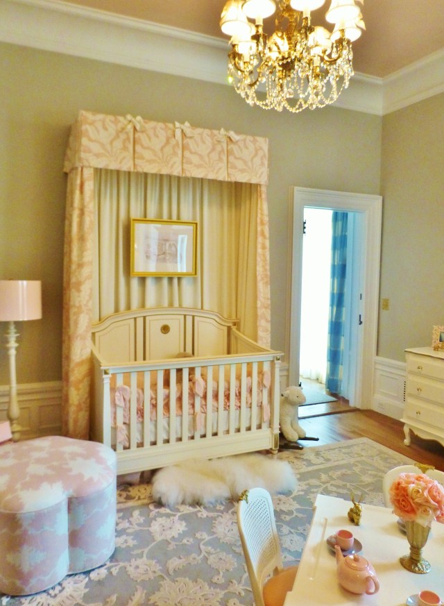 Bright white trim and a high-gloss blush ceiling are striking against the warm grey walls in this baby's room.