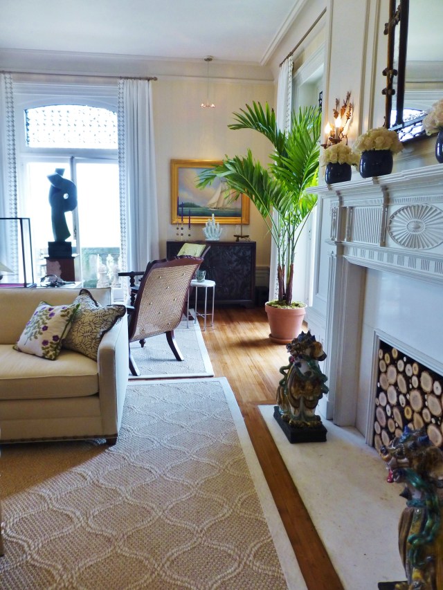 In this image, you can see that two woven sisal area rugs were used to define the separate seating areas.  I also appreciate how the sculpture is placed in the window, its dark profile is even more beautiful when outlined in the sun.