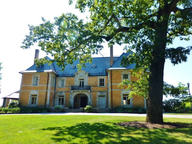 Seen here from the entrance drive, the mansion's symmetrical Beaux Arts style façade is framed by another mature tree in the foreground.  I just adore the light grey stone-work, contrasting with the joyful color of the yellow brick!
