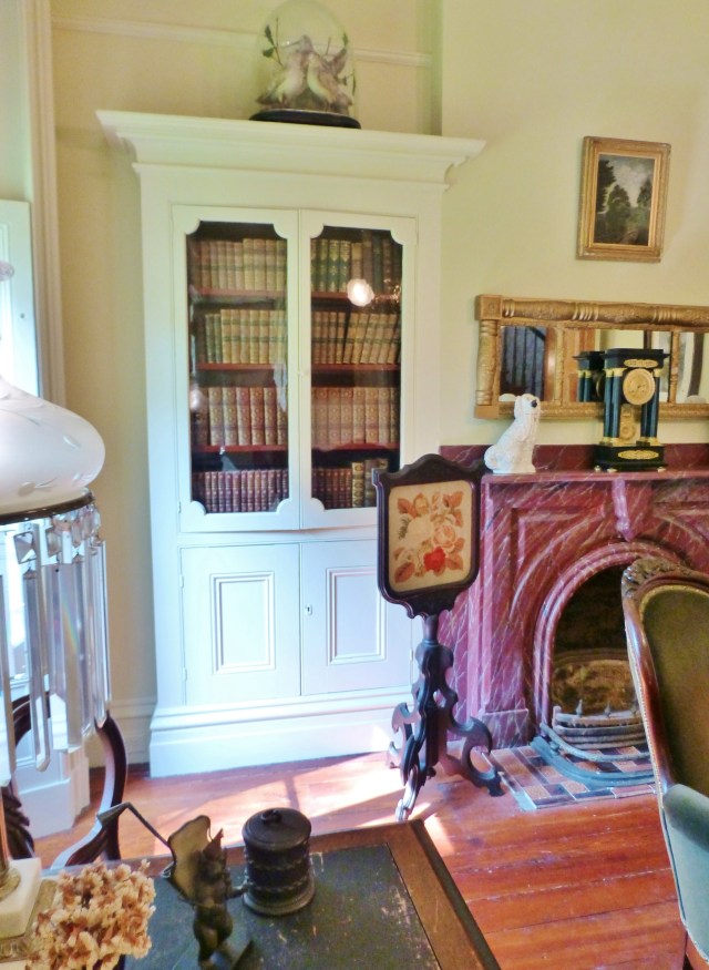 Here's a closeup of the fireplace and bookcase. Notice the pretty fire-screen to the left of the mantel. The needlepoint might have been hand worked by the lady of the house, since this was an acceptable pass-time. And did you see the glass cloche atop the bookcase? It houses more bird taxidermy--these are American Woodcocks.