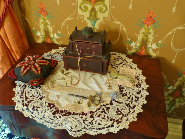 The dining room also features a sewing corner, with various implements that might be used by the lady of the house. I'm very fond of the thread holder in this image, which kept all the different colors of embroidery floss from getting tangled up.