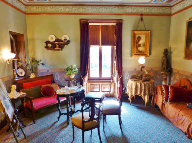 The right hand corner of the room features a chaise draped with a Paisley Shawl (very trendy at the time) and the left corner is set up for tea.