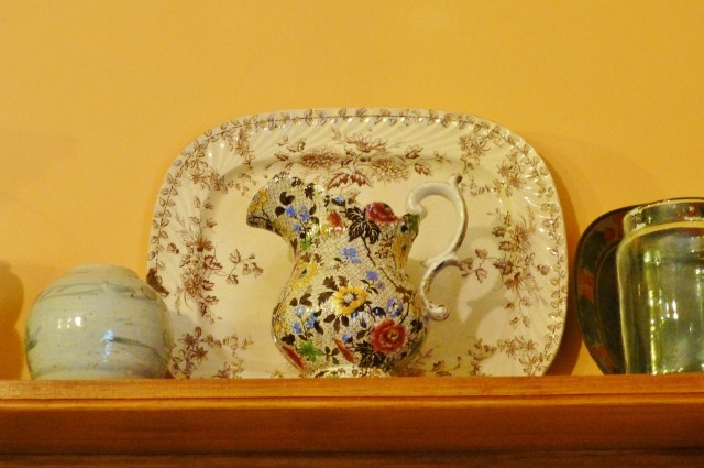 The open shelving contains many pretty and useful objects like the Stoneware platter and jug seen here.