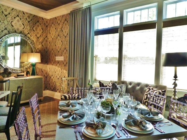 Rather than us a single large dining table, the Mecox designers chose to use 3 separate square dining tables, with a different style of chair at each table.  There is also additional seating in the dining room, like the tufted settee in front of the large front windows.