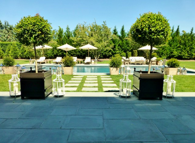 The terrace leads down to the amazing pool area with umbrellas and chaise lounges.