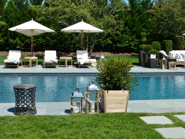 A detail of the lovely chaise lounges beneath useful umbrellas found poolside at the 2014 Hampton Designer Showhouse.