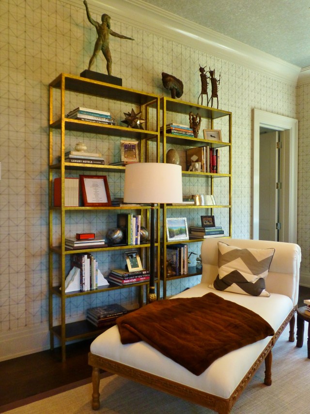 On the room's entry wall the designer placed a pair of clean-lined gilded etageres.  Beautiful and interesting accessories were artfully arranged near an oversized chaise lounge.  I thought the placement of that beautiful floor lamp was an interesting choice--in front of and between the shelves and the chaise.