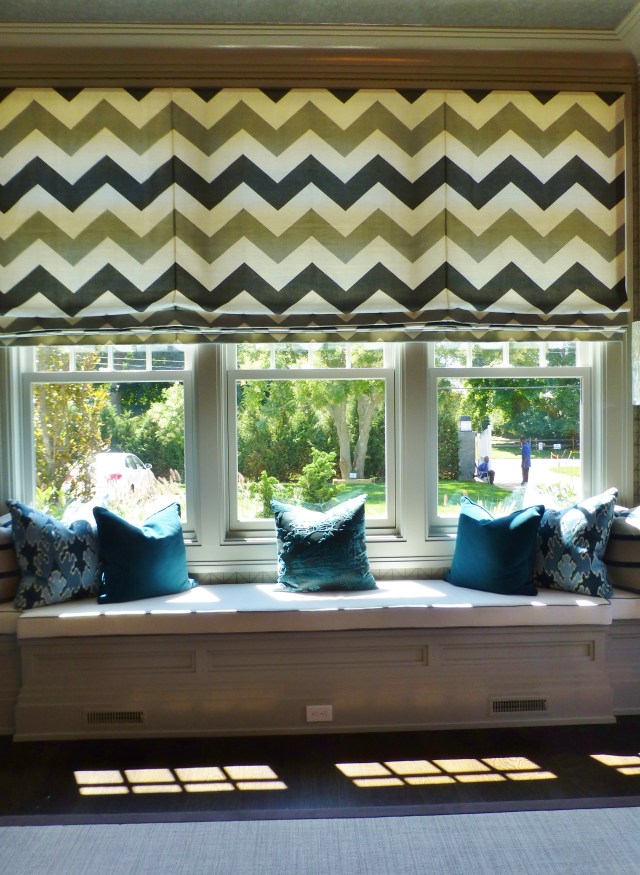 To the left of the main seating area was this ample window seat overlooking the front lawn.  The designer chose a graphic chevron pattern for the single large roman shade.  Custom pillows in contrasting colors look so inviting here!