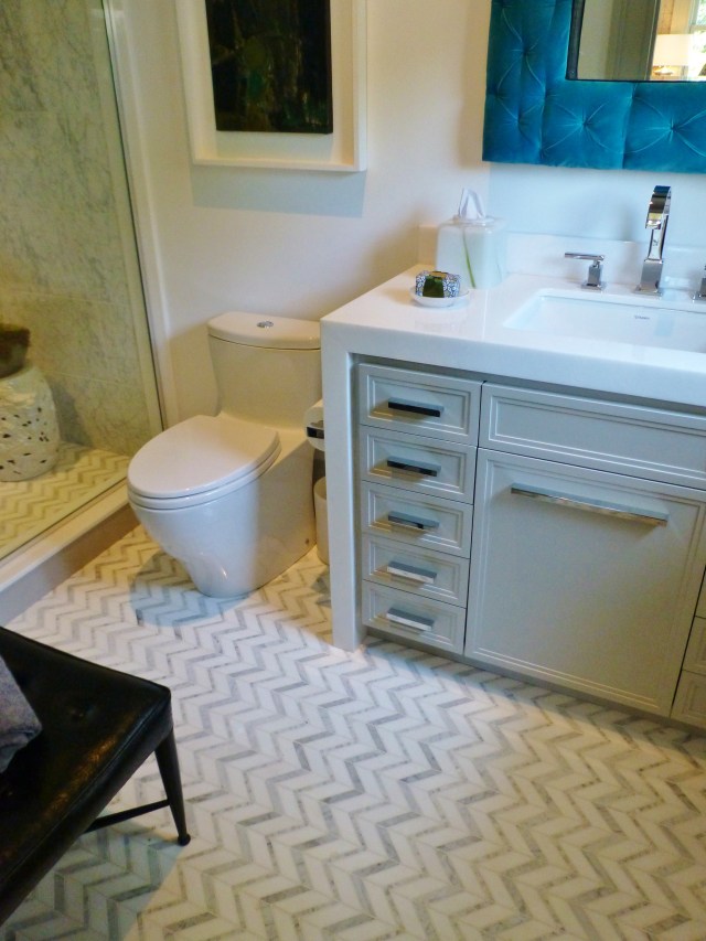Just off the library is this beautiful full bath.  The chevron tile floors echo the window treatment fabrics in the adjacent room.  Notice the white waterfall countertop on the vanity and how it wraps around and down the side.