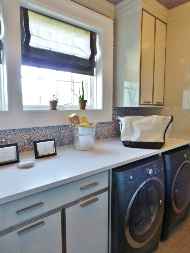The laundry room at the 2014 Hampton Designer Showhouse was long and narrow.  I love that the designers kept things clean and simple, with tailored roman shades at the windows, white countertops and white cabinetry with sleek nickel trim.