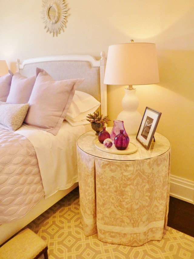 The designer chose to use mismatched end tables on either side of the bed.  At the right is this lovely skirted table.  The fabric is so pretty with its lavender damask pattern and I really like the added detail of the ivory ribbon tape, applied just a few inches from the hem. You can also take a closer look at the bedding in this photo.  Such a pretty combination of fabrics and textures were used.