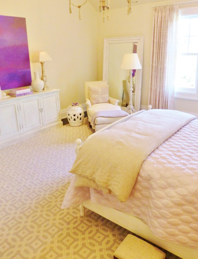Here's a look across the room at the corner with the linen-covered chair and ottoman.  Notice the extra large floor mirror leaning off to the right, and the pretty white floor lamp.  In this photo, you can also get a better feel for the absolutely stunning area rug in this space.  The rug is large enough to cover the entire floor, with just a little bit of hardwood peeking out at the sides.  The lavender and ivory trellis pattern is perfect in this soothing bedroom.