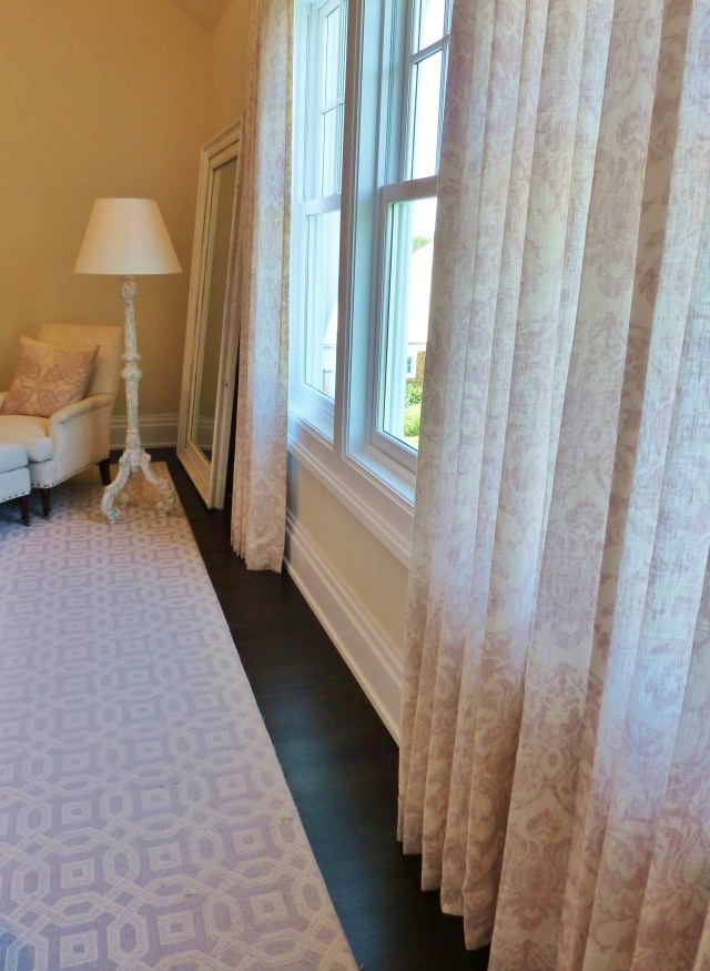Here's a shot featuring the pretty linen draperies.  They're very simple full-length panels in the same printed damask pattern as the skirted table by the bed.  They're very elegant and subtle and the scale of the pattern combines beautifully with the area rug.