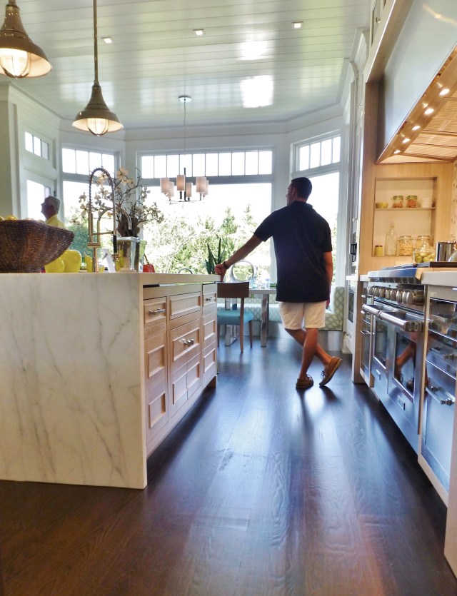 Entering the kitchen from the dining room, you can appreciate the rich wood floors, a wonderful contrast to the white beadboard ceiling. You'll also notice the waterfall marble top on the large kitchen island.