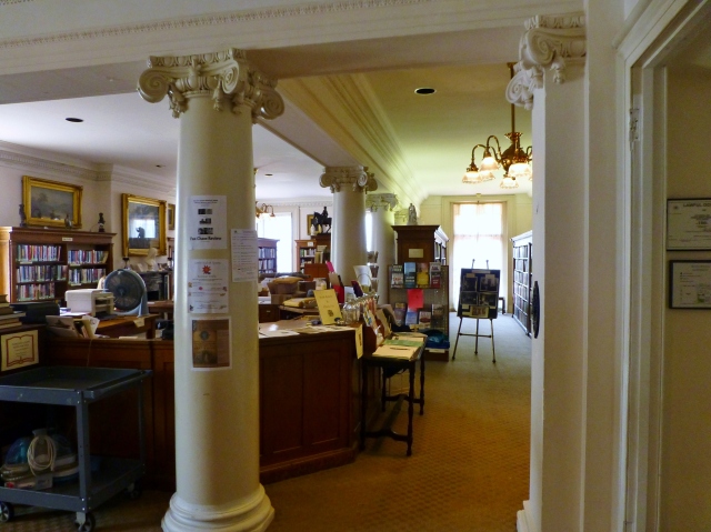 The main entry brings you up some stairs and into the library which was created in 1910. As an independent circulating library, it lends current fiction, popular bestsellers, nonfiction, children’s literature, classic literature and reference materials.  Walls between bedrooms were removed and beautiful columns with dentil moldings were added to open up the second floor of the mansion.