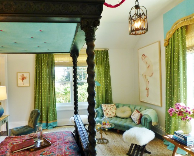 Here's a view through from the bed.  Check out the inside of the bed canopy:  isn't it cute having pink contrasting buttons up there, to pull out the pink in the ethnic bedspread?   I also like the cornered tufted sofa across the room.  The artwork above the sofa sparked quite a lot of buzz...many viewers felt that the female subject looked pained or that the artwork was disturbing in this bedroom.  What do you think?