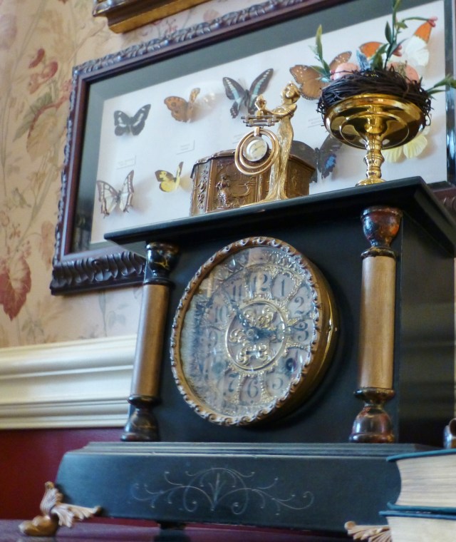 This turn-of-the-century slate 'black clock' is in our dining room, where an antique pocket watch is displayed on top. The framed butterflies were a gift from a dear friend and were collected from all over the world.