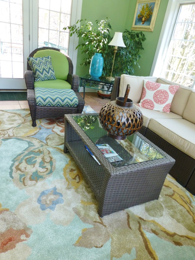 A comfortable chair and ottoman provide another spot to relax and take in the outdoor views, in the vibrant space. 