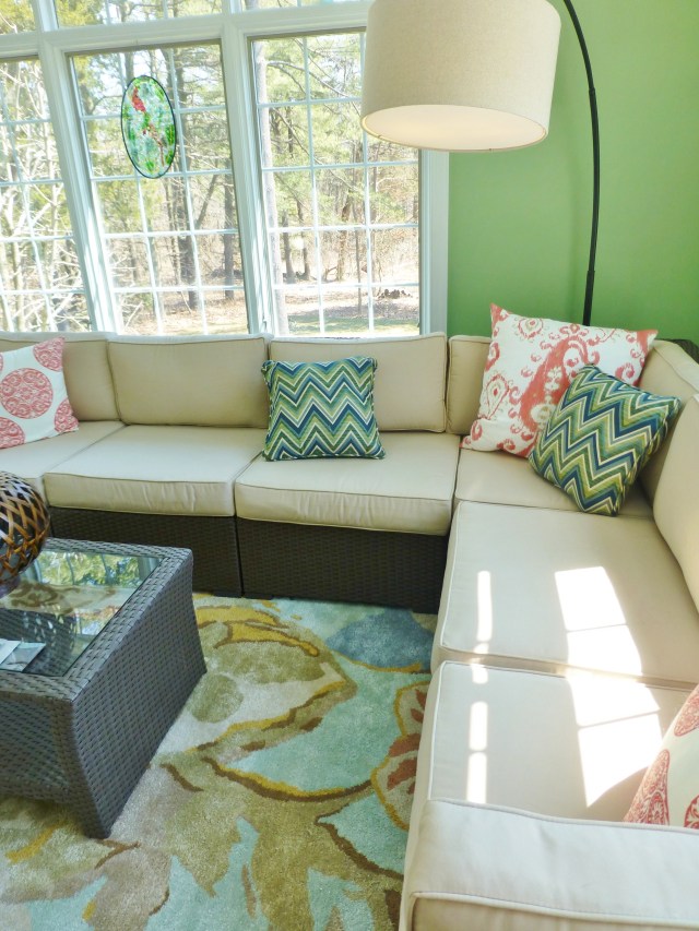 A tall arc lamp provides nighttime reading light and anchors the corner of the sectional.   Colorful pillows scattered throughout, add pattern and provide pops of color on the neutral sectional cushions.  