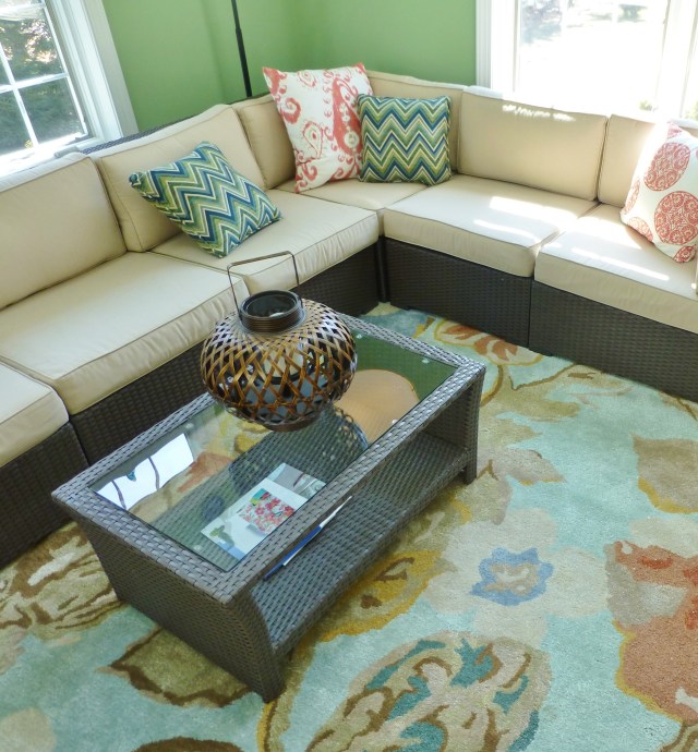 The artful wool rug provides soft comfort underfoot, while acting like artwork in the large space.  The colors tie the whole room together and softer color palette helps tame the vibrant green walls.