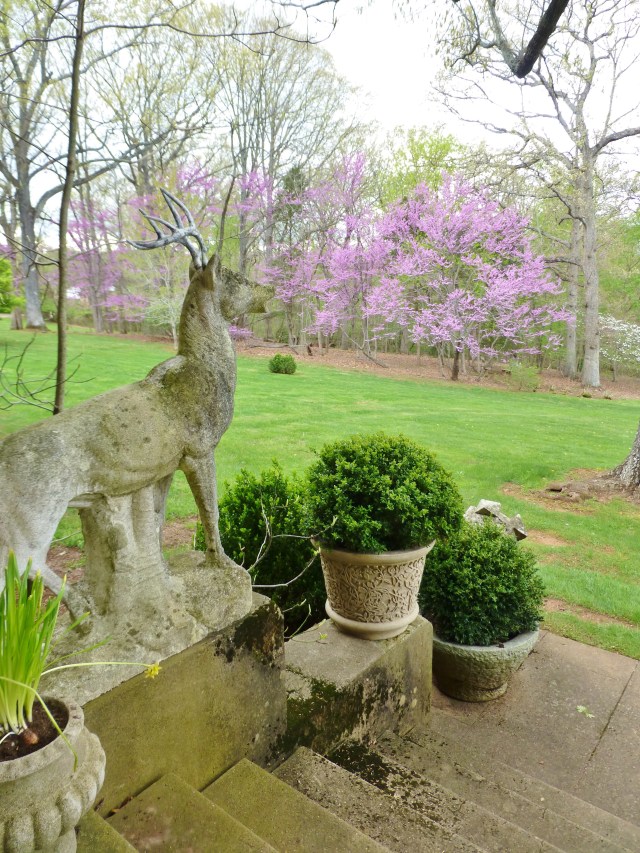 A pair of large stone stag sculptures flank the stairs and look out across the lawn.