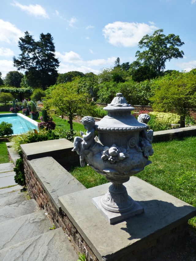 Another pair of beautiful urns adorn the stairway, leading down to the pool.   Luscious garden plantings surround this exquisite space.